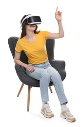 Photo of Smiling woman using virtual reality headset while sitting in armchair against white background