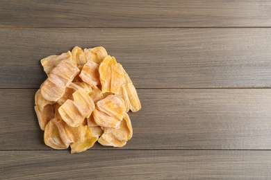 Delicious dried jackfruit slices on wooden table, top view. Space for text