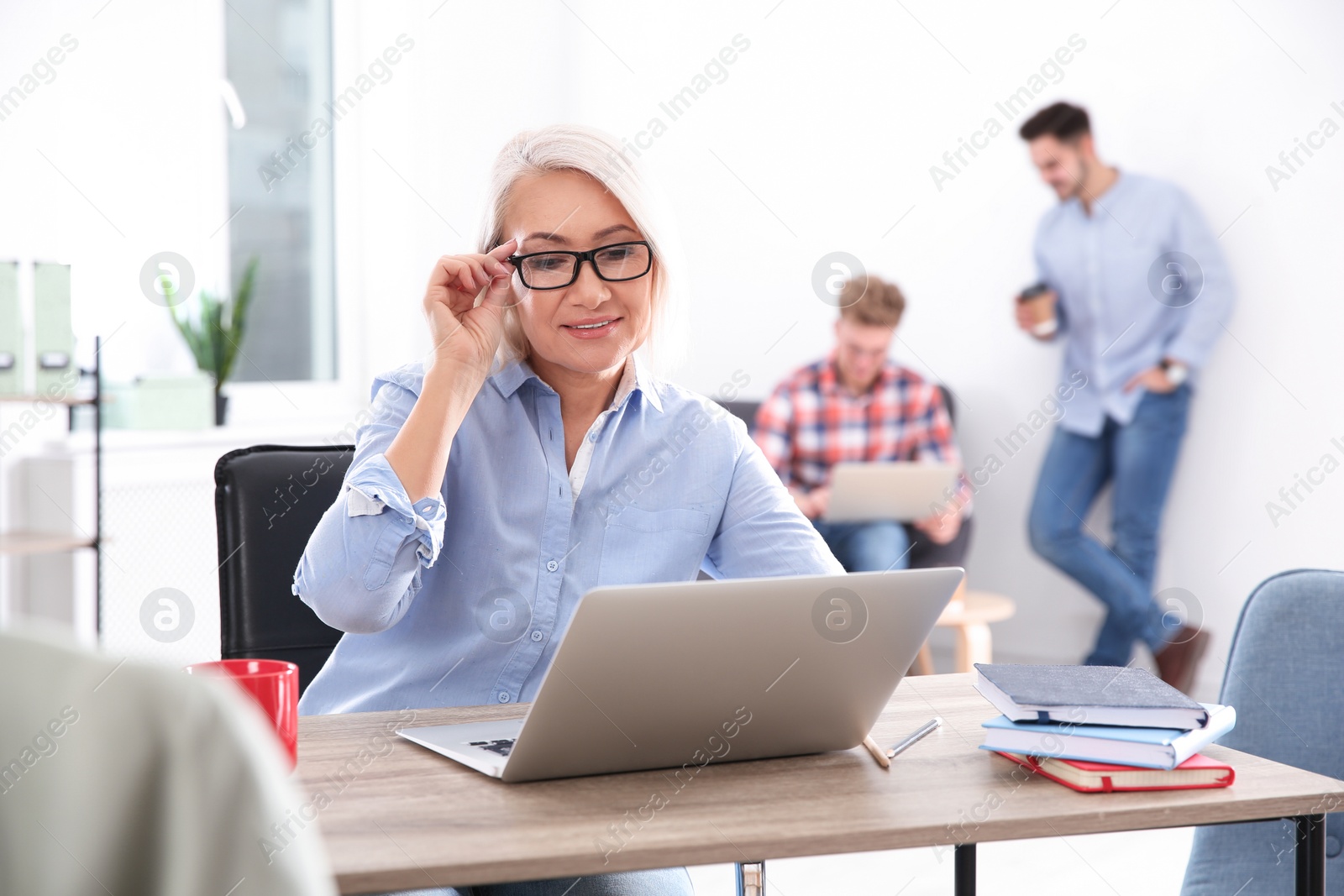 Photo of Businesswoman with colleagues working in office. Professional communication