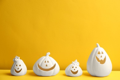 Photo of Jack-o-Lantern candle holders on yellow background. Halloween decor