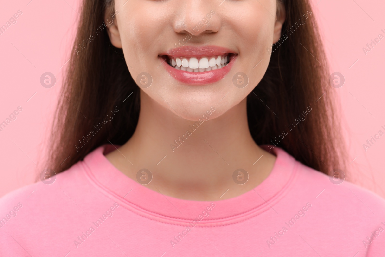 Photo of Woman with clean teeth smiling on pink background, closeup