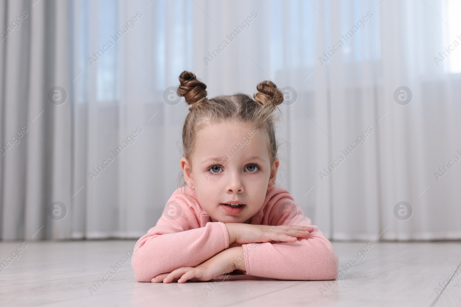 Photo of Cute little girl lying on warm floor at home. Heating system