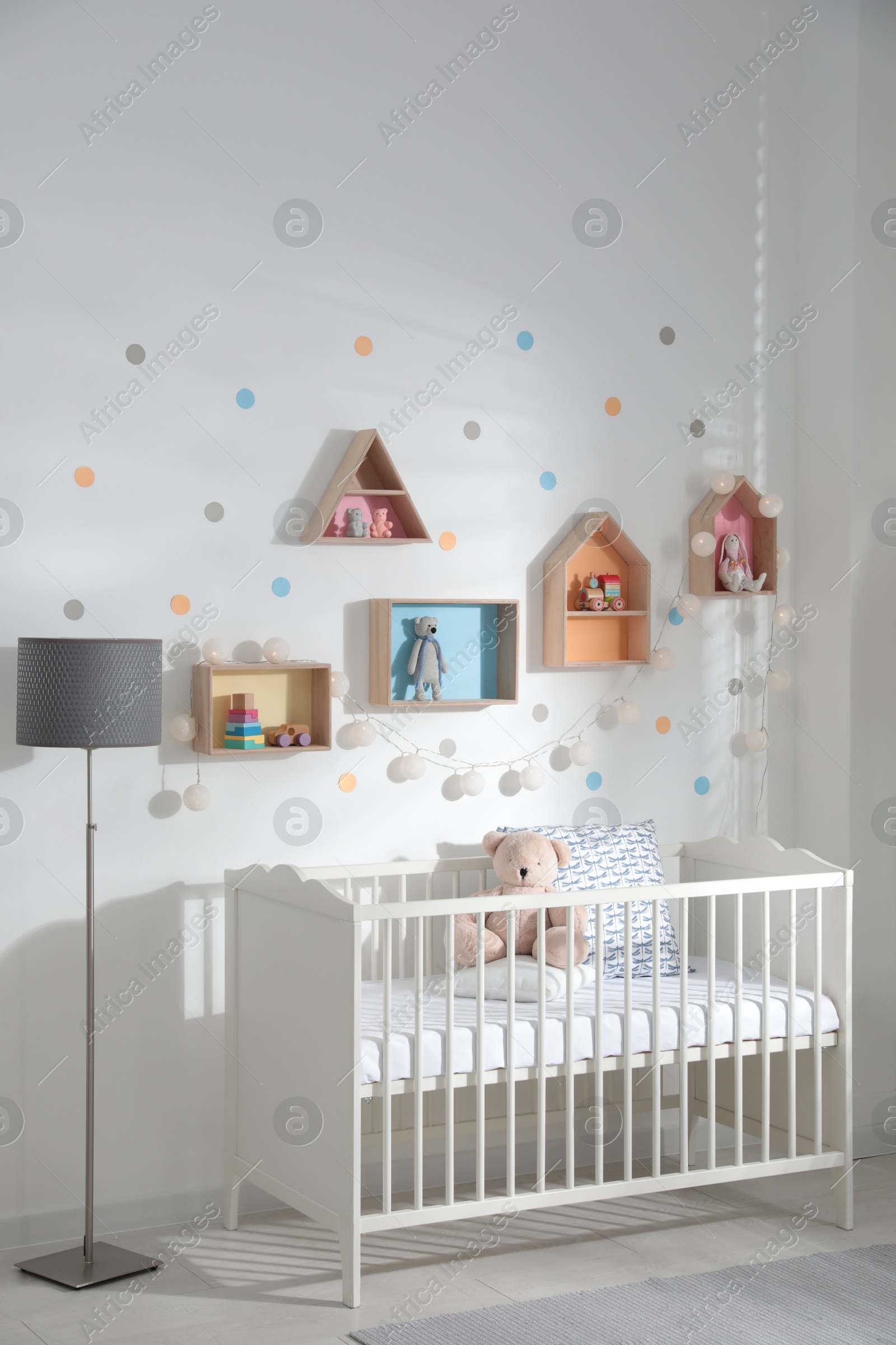 Photo of Cute children's room with house shaped shelves and crib. Interior design