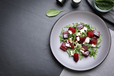 Photo of Delicious beet salad served on black table, flat lay. Space for text