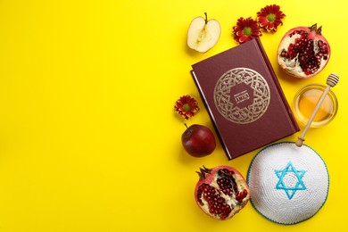 Photo of Flat lay composition with Rosh Hashanah holiday attributes on yellow background. Torah book with text in hebrew