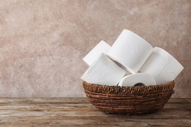 Photo of Bowl with toilet paper rolls on wooden table. Space for text