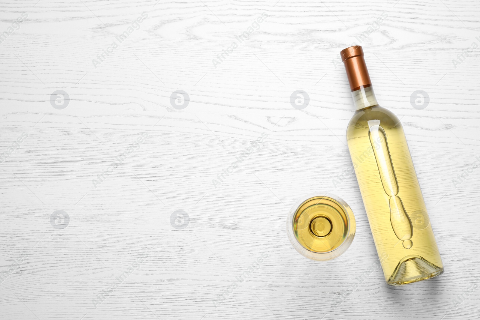 Photo of Glass and bottle with white wine on wooden background, flat lay. Space for text