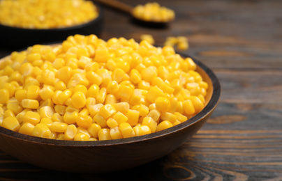 Delicious canned corn in bowl on wooden table, closeup