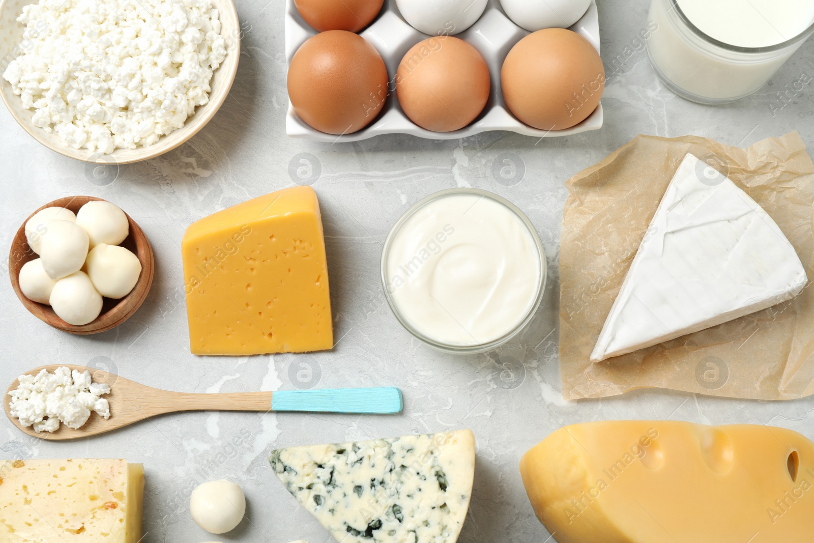 Photo of Different dairy products on marble table, flat lay