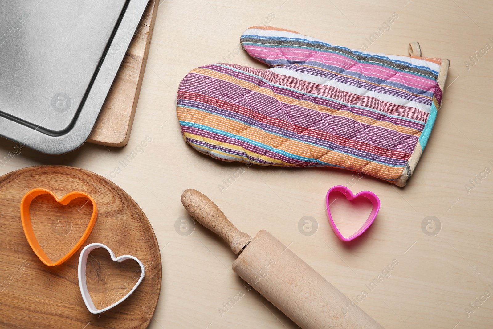 Photo of Flat lay composition with oven glove and kitchenware on wooden table