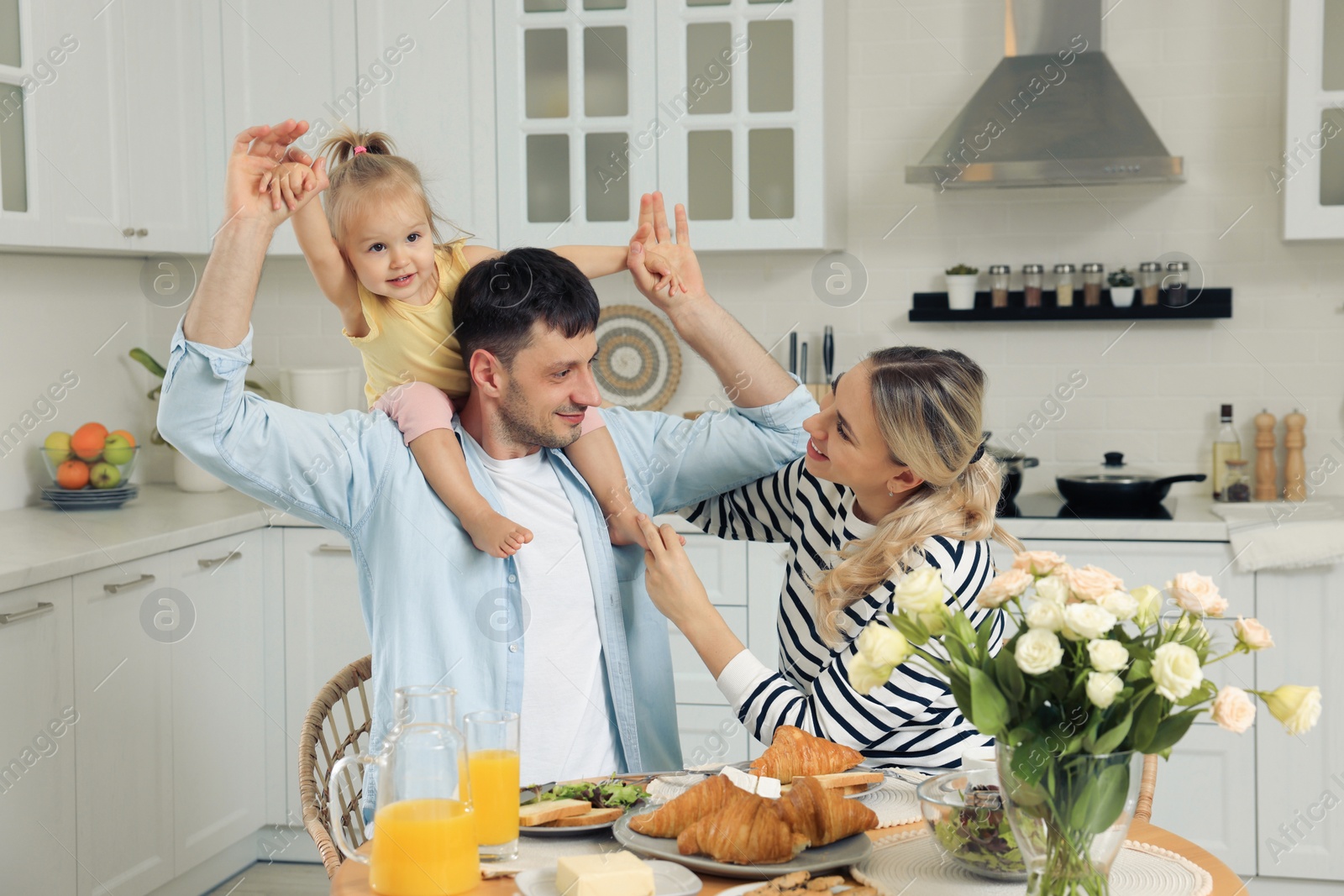 Photo of Happy family having fun during breakfast in kitchen