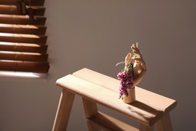 Decorative hand with flowers on wooden stand indoors, space for text. Interior design