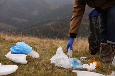 Woman with trash bag collecting garbage in nature, closeup