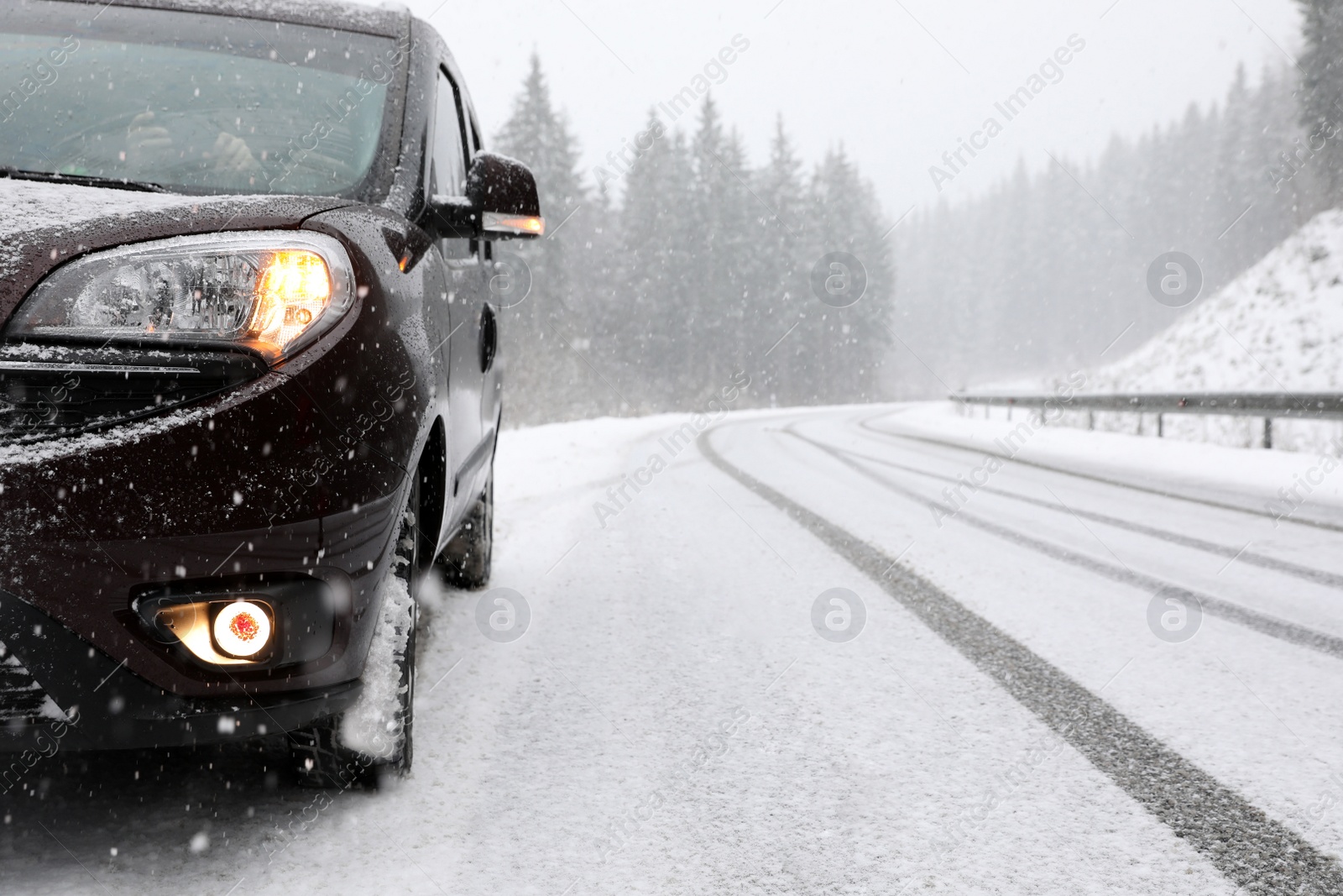 Photo of Country road with car on snowy winter day. Space for text