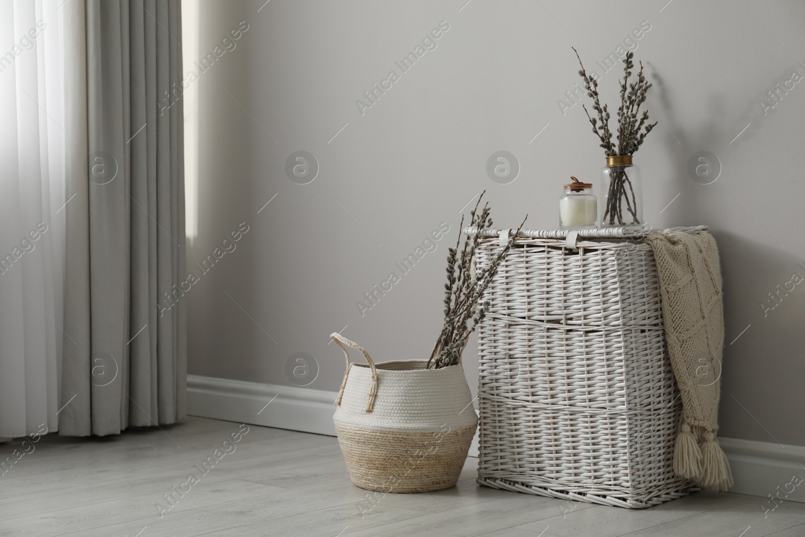 Photo of Fresh pussy willow branches and wicker baskets indoors