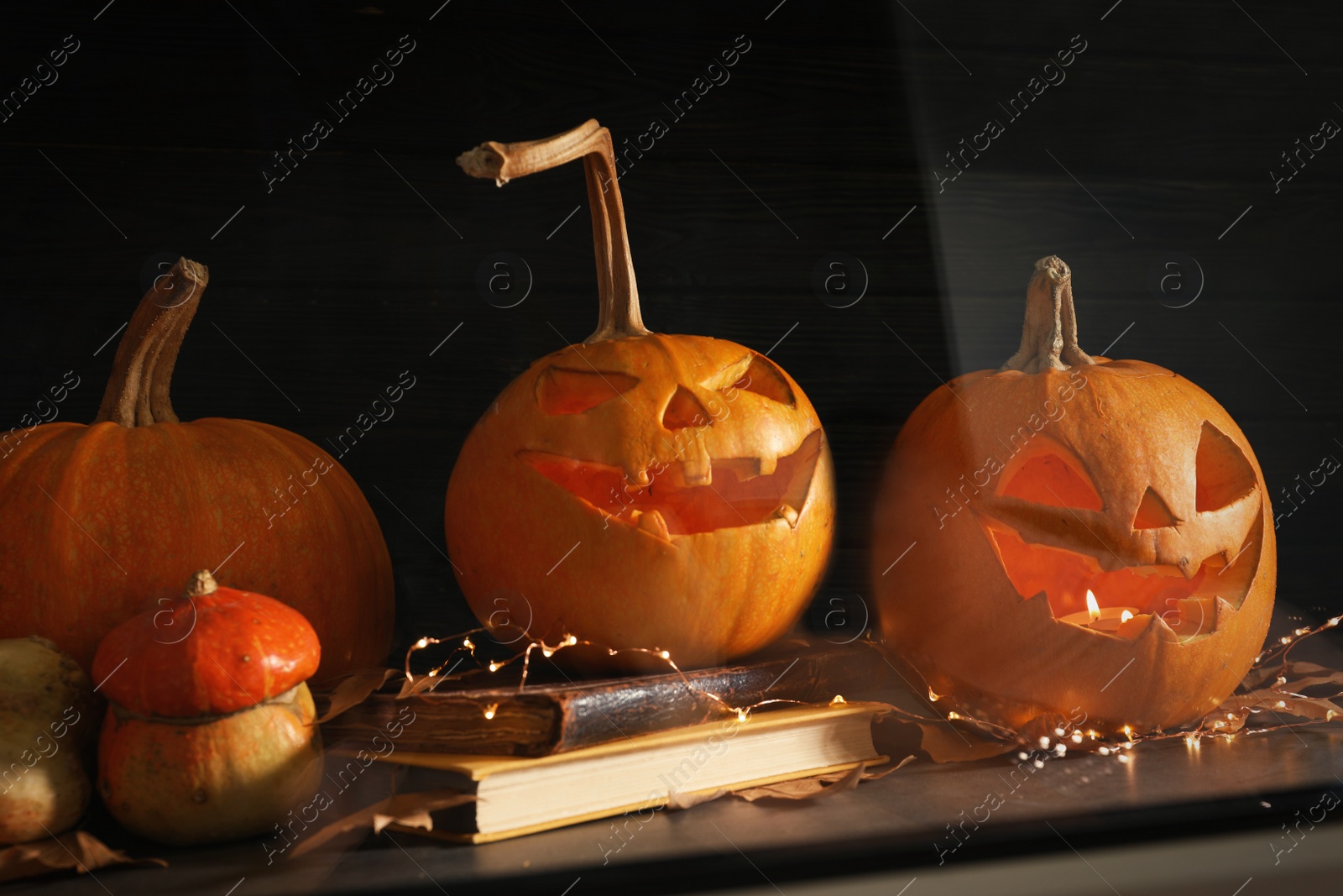 Photo of Halloween pumpkin heads. Jack lanterns on windowsill, view through glass