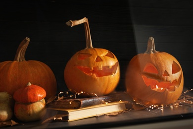 Photo of Halloween pumpkin heads. Jack lanterns on windowsill, view through glass