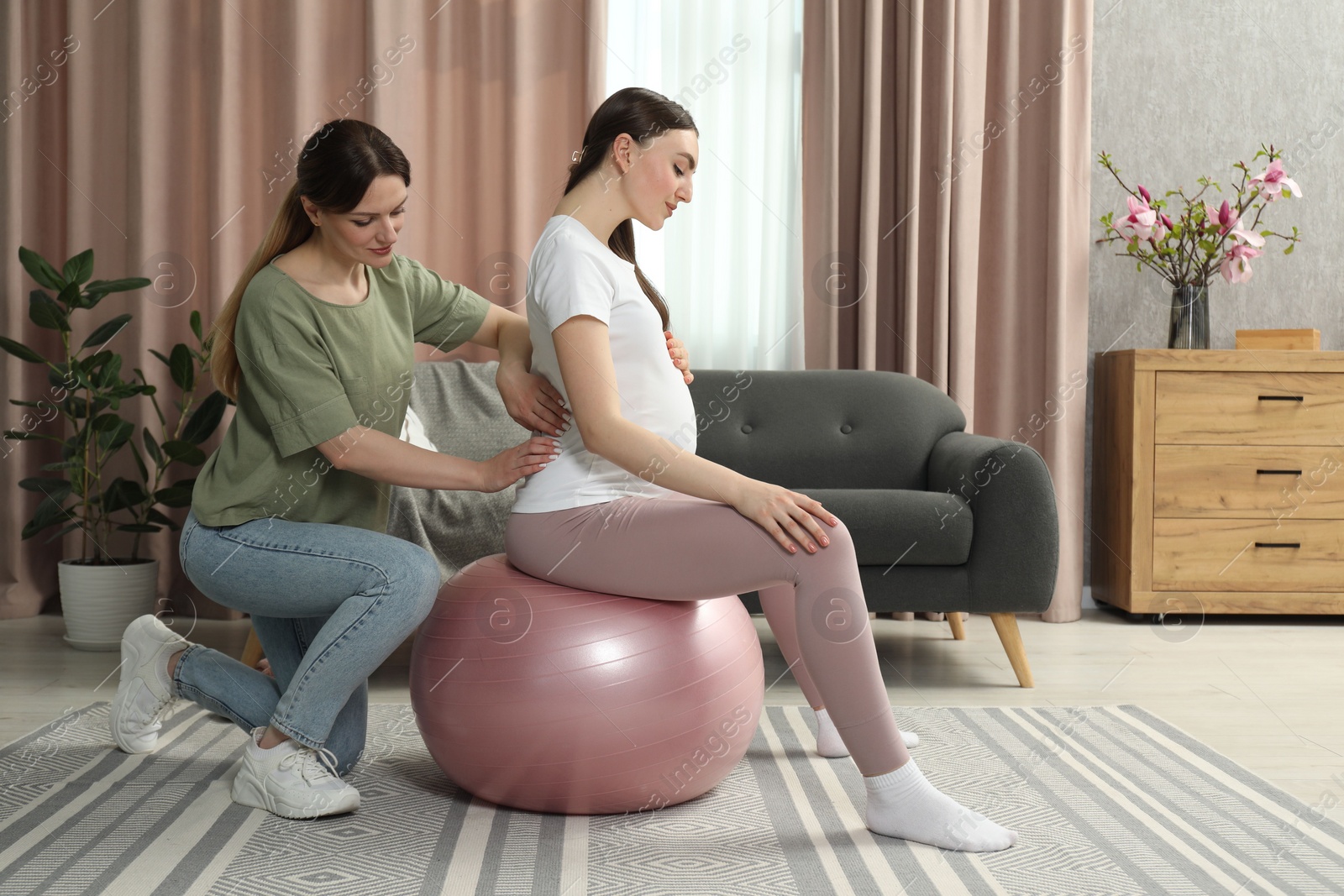 Photo of Doula massaging pregnant woman at home. Preparation for child birth