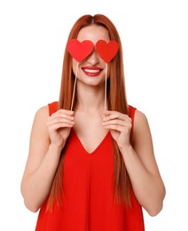 Photo of Young woman in red dress covering her eyes with paper hearts on white background