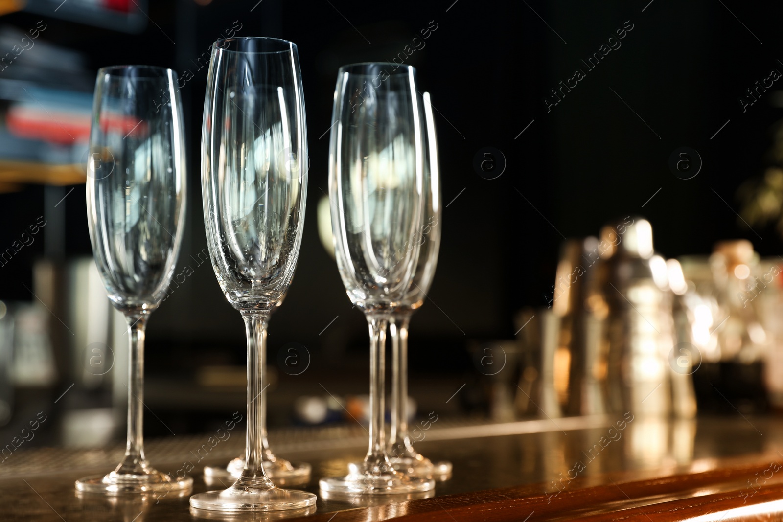 Photo of Empty clean champagne glasses on counter in bar. Space for text