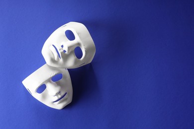 Theater arts. White masks on blue background, top view. Space for text