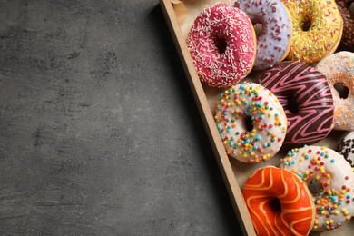 Top view of yummy donuts with sprinkles in box, space for text