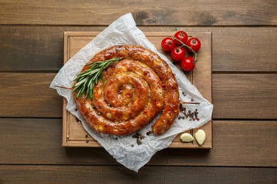 Delicious homemade sausage with spices and tomatoes on wooden table, top view