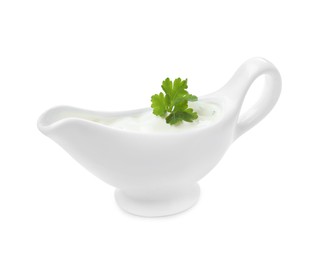 Photo of Ceramic sauce boat with sour cream and parsley isolated on white