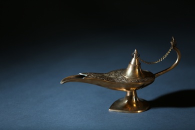 Photo of Aladdin lamp of wishes on table against dark background