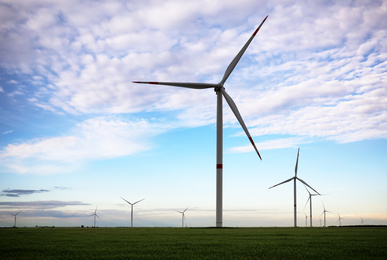 Photo of Beautiful view of field with wind turbines. Alternative energy source