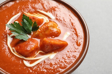Photo of Bowl of delicious butter chicken on color background, closeup. Traditional indian dish