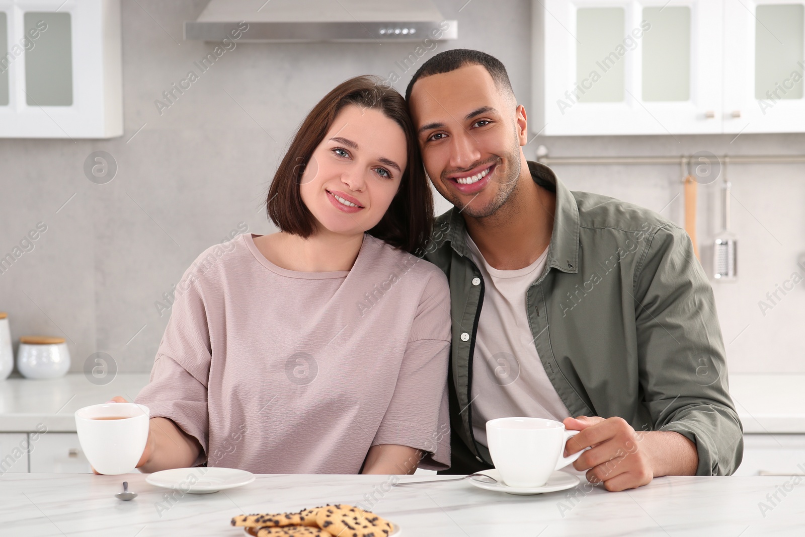 Photo of Dating agency. Happy couple spending time together at table in kitchen