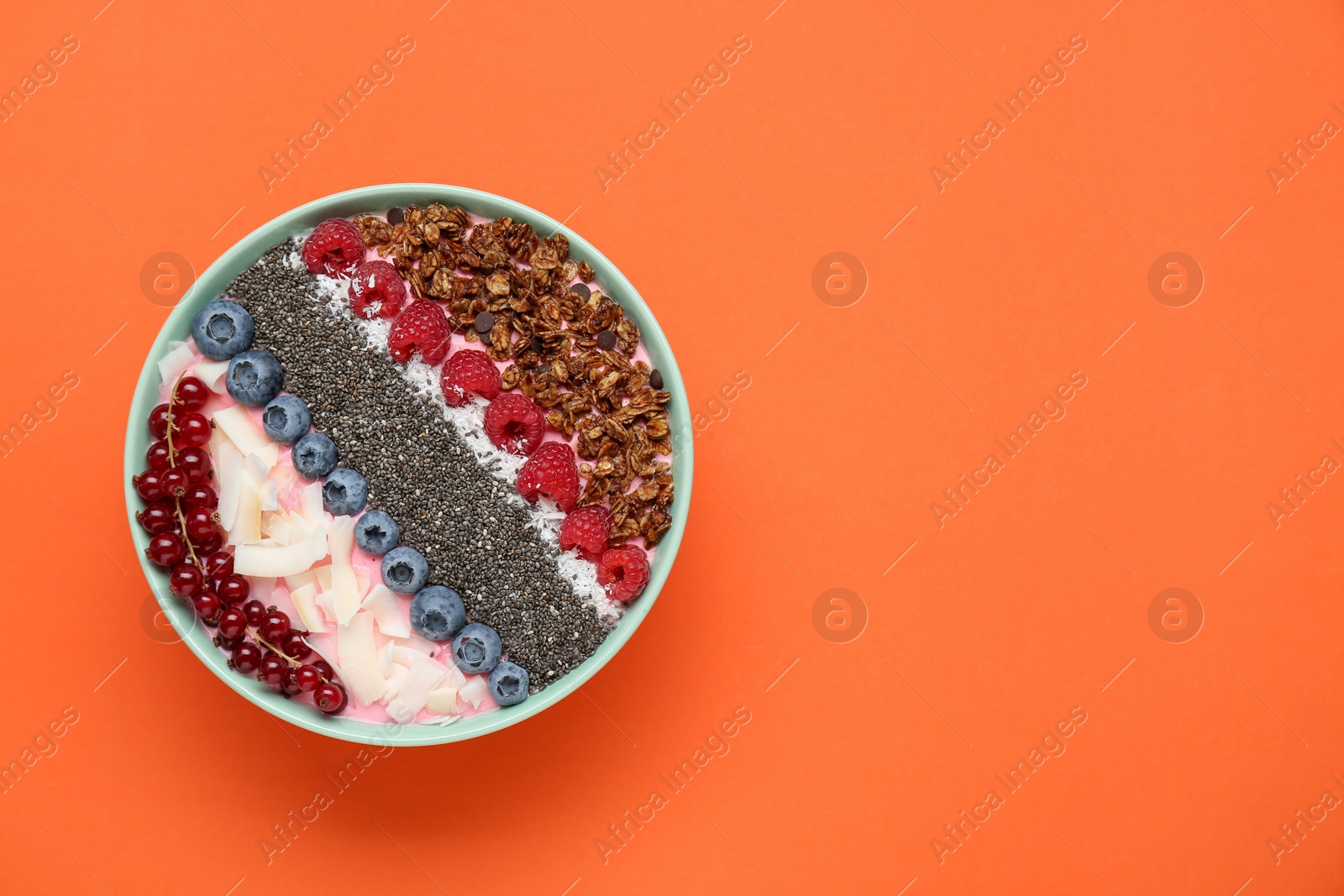 Photo of Tasty smoothie bowl with fresh berries and granola on orange background, top view. Space for text