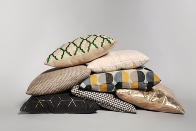 Pile of stylish decorative pillows on light background