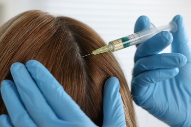 Trichologist giving injection to patient in clinic, closeup