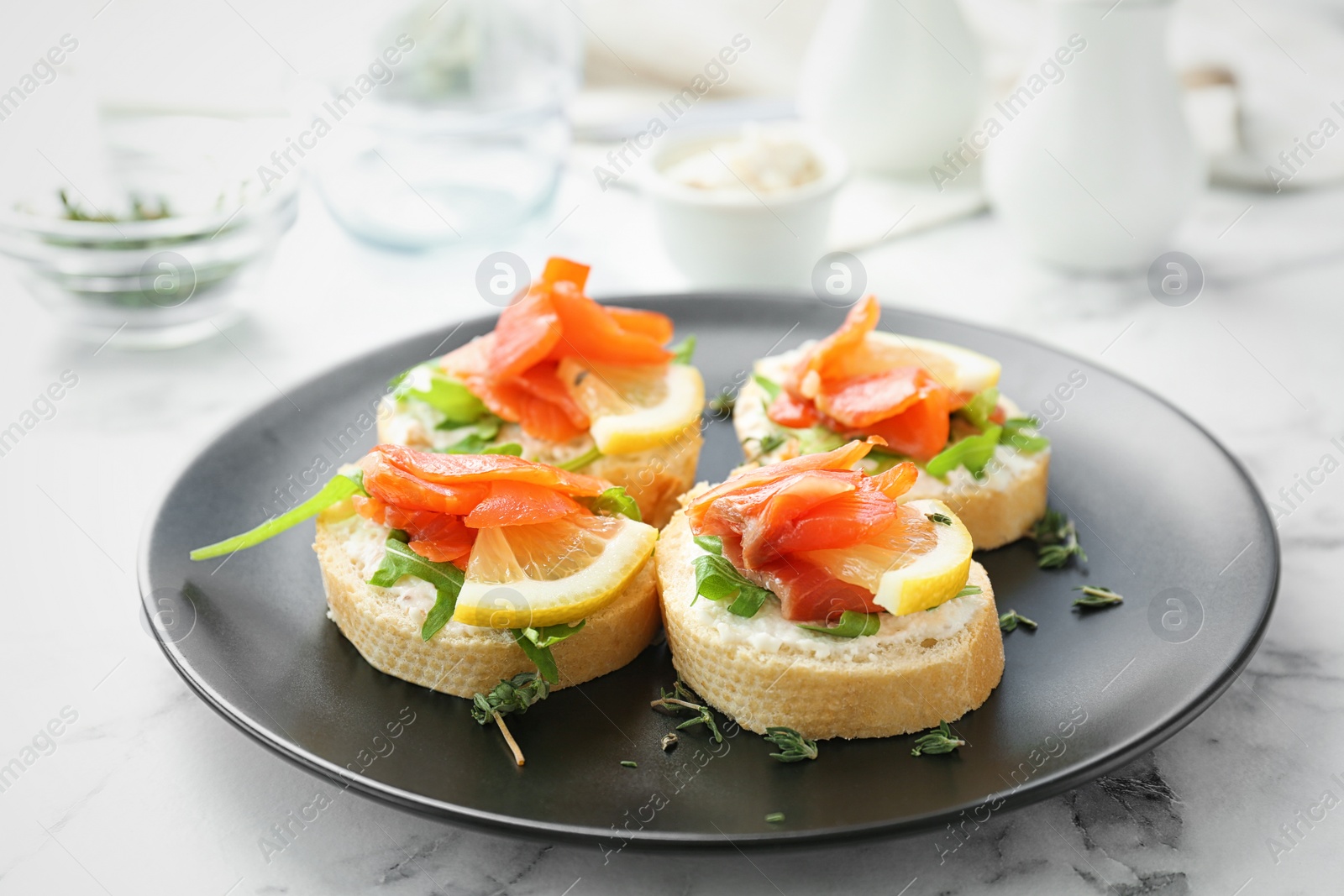 Photo of Plate of tasty sandwiches with fresh sliced salmon fillet on table