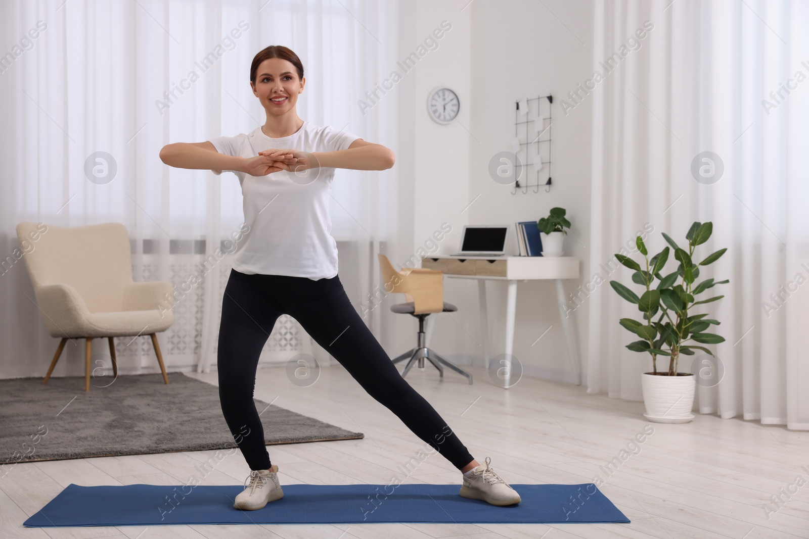 Photo of Happy woman doing morning exercise at home, space for text