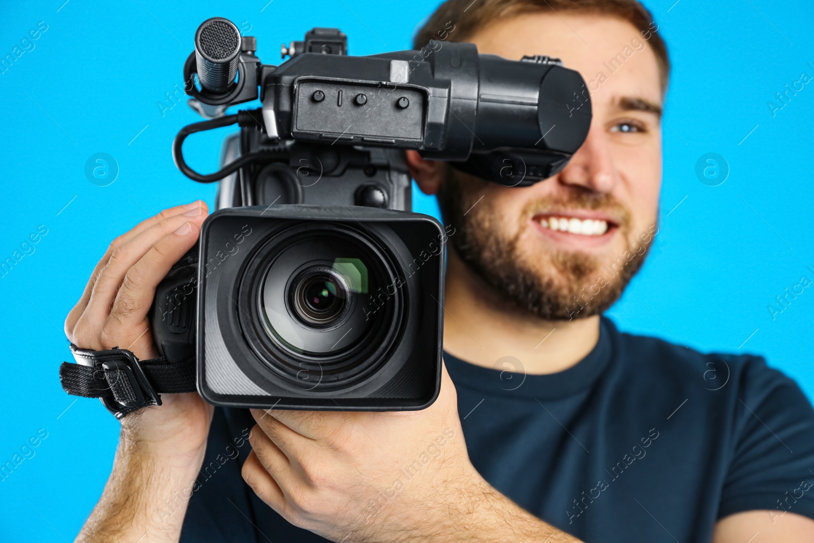 Photo of Operator with professional video camera on blue background