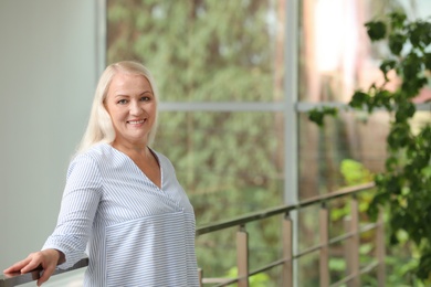 Photo of Portrait of beautiful older woman against blurred background with space for text