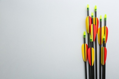 Photo of Plastic arrows on light grey background, flat lay with space for text. Archery sports equipment