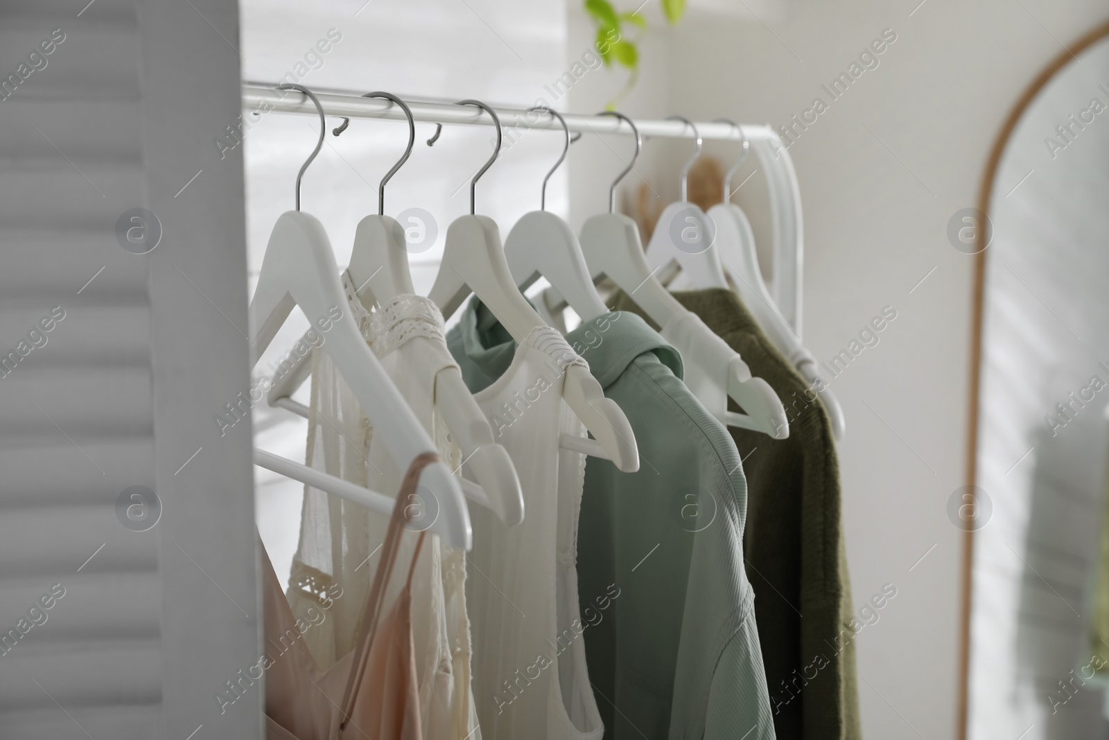 Photo of Rack with different stylish clothes in dressing room, closeup