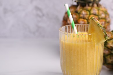 Photo of Tasty pineapple smoothie and fresh fruits on white table, closeup. Space for text