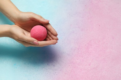 Photo of Woman holding bath bomb over water with foam, closeup. Space for text