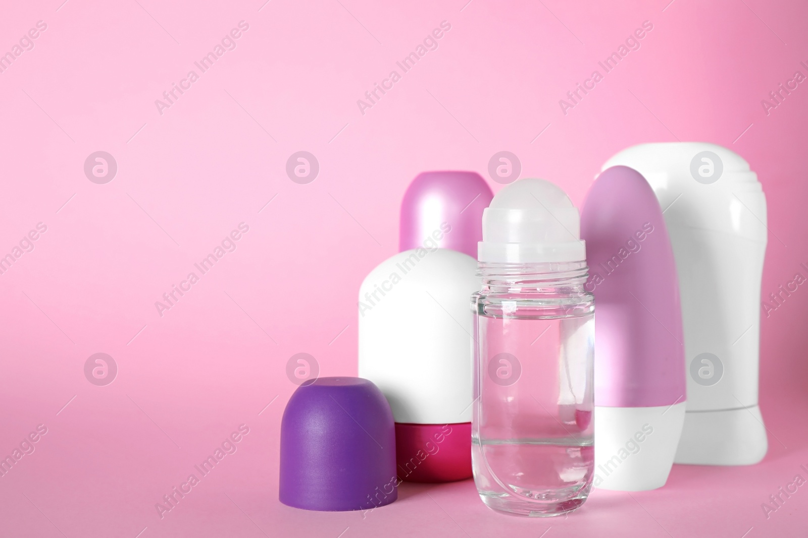 Photo of Set of different female deodorants on pink background