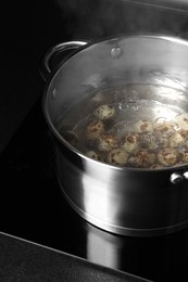 Photo of Cooking quail eggs in pot on electric stove