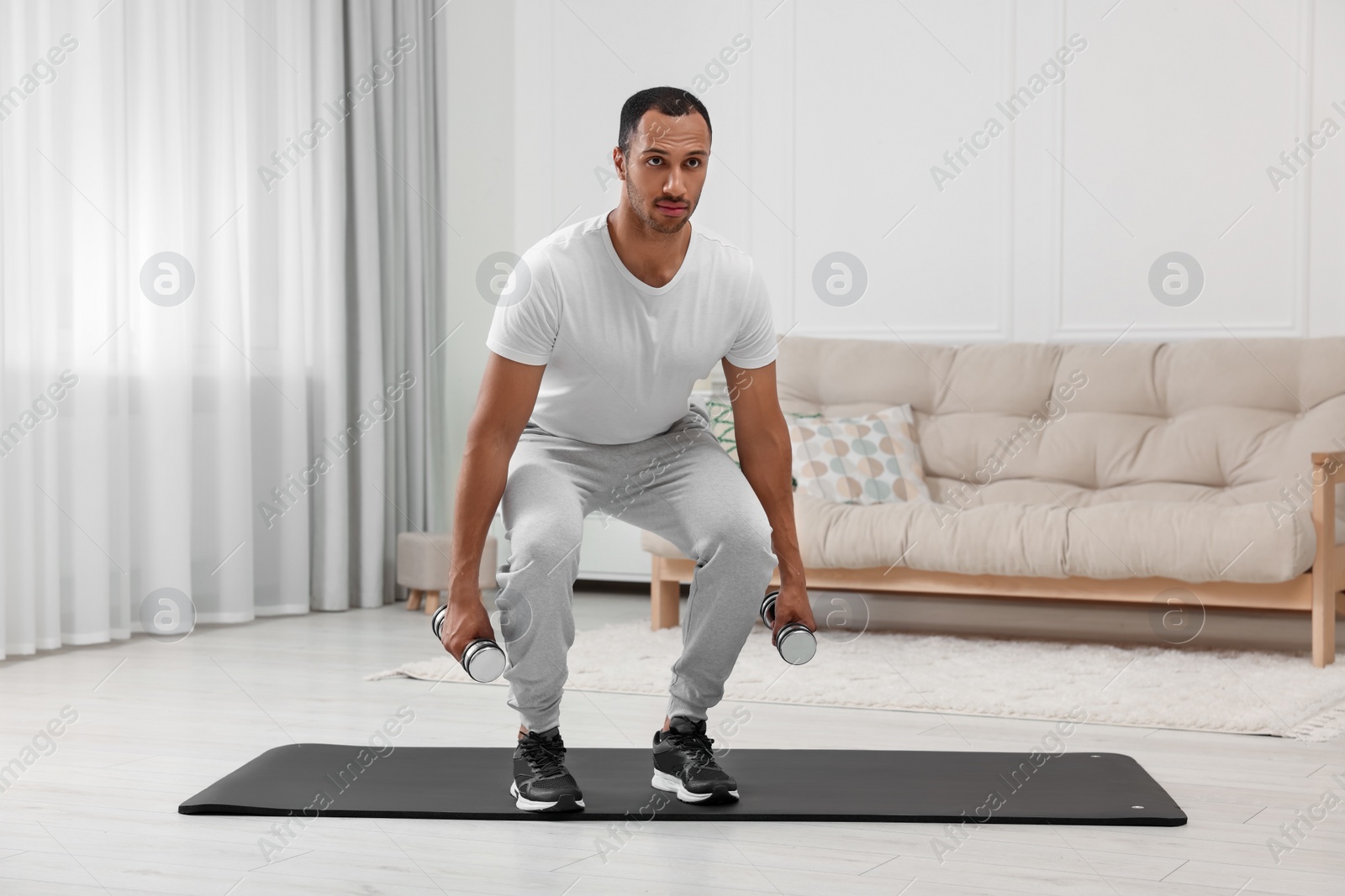 Photo of Man doing morning exercise on fitness mat at home