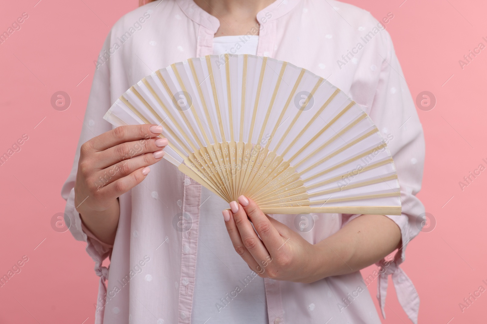 Photo of Woman with hand fan on pink background, closeup