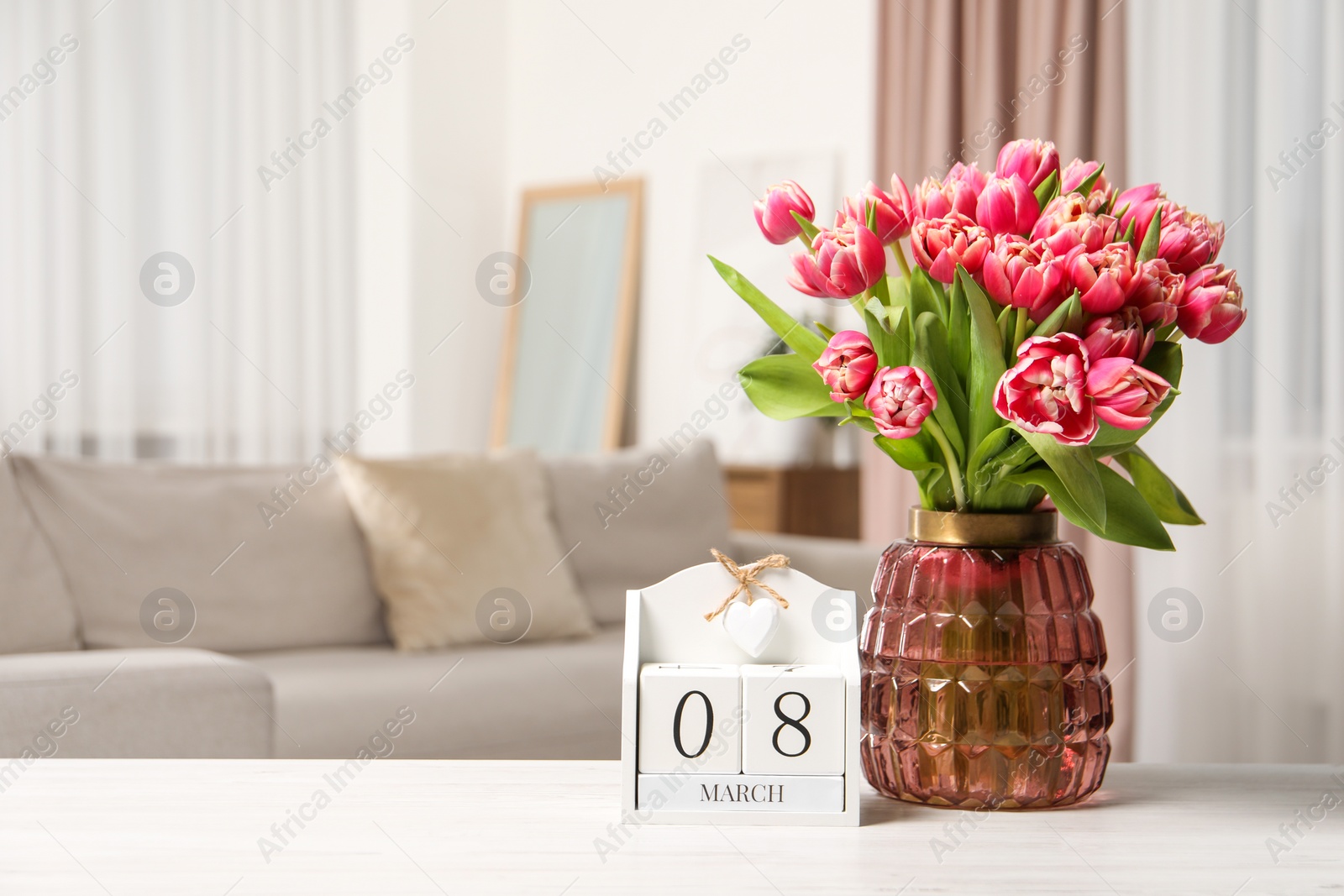 Photo of International Women's day - 8th of March. Block calendar and bouquet of beautiful tulips on white wooden table. Space for text