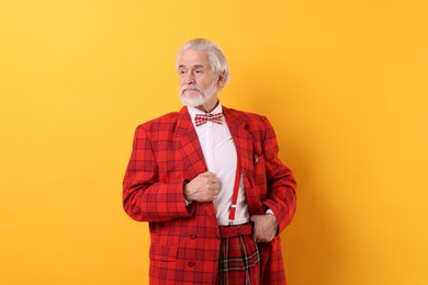 Photo of Portrait of grandpa with stylish red suit and bowtie on yellow background