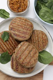 Tasty grilled vegan cutlets served on white table, flat lay